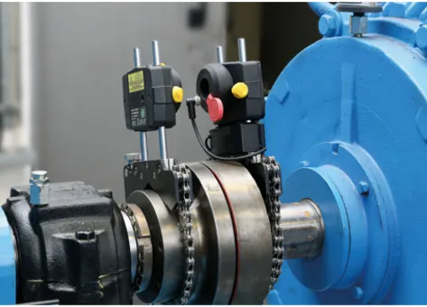 Laser alignment heads mounted across a coupling between a motor and driven machine